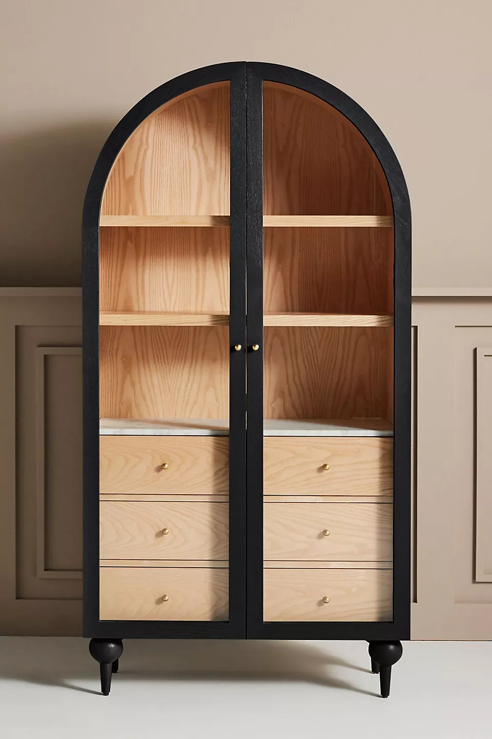 A wooden storage cabinet. An arched wood cabinet.